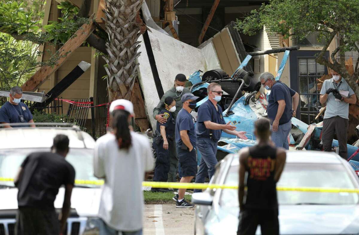 Two police officers hug as authorities investigate the scene where an HPD officer was killed and another was critically injured when a helicopter crashed into Greenspoint apartment complex Saturday, May 2, 2020, in Houston.