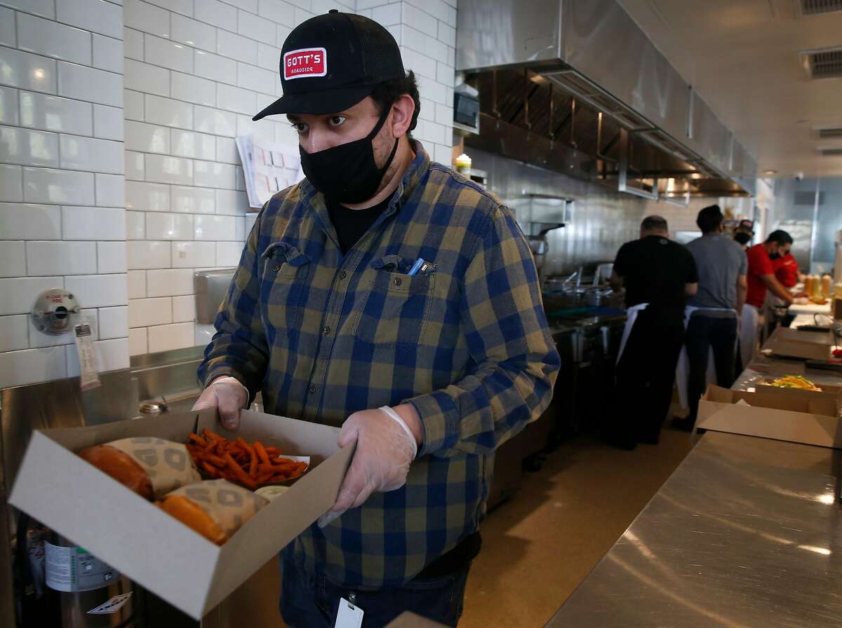 Raul Vasquez packs a lunch for pickup at Gott's Roadside restaurant at the Ferry Building in San Francisco, Calif. on Saturday, May 2, 2020. Gott's Roadside restaurant has reopened its San Francisco location for takeout service using social distancing guidelines.