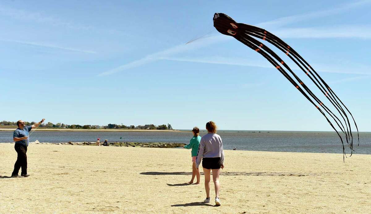 Guilford, Connecticut, Saturday, May 2, 2020: Mario Bruno of Glastonbury, left, with his daughters Karina, 13, center, and Isabella, 16, right, as the fly a kite together while enjoying the e warmth and sunshine Saturday at Jacob's Beach in Guilford during the Coronavirus / Covid-19 pandemic.