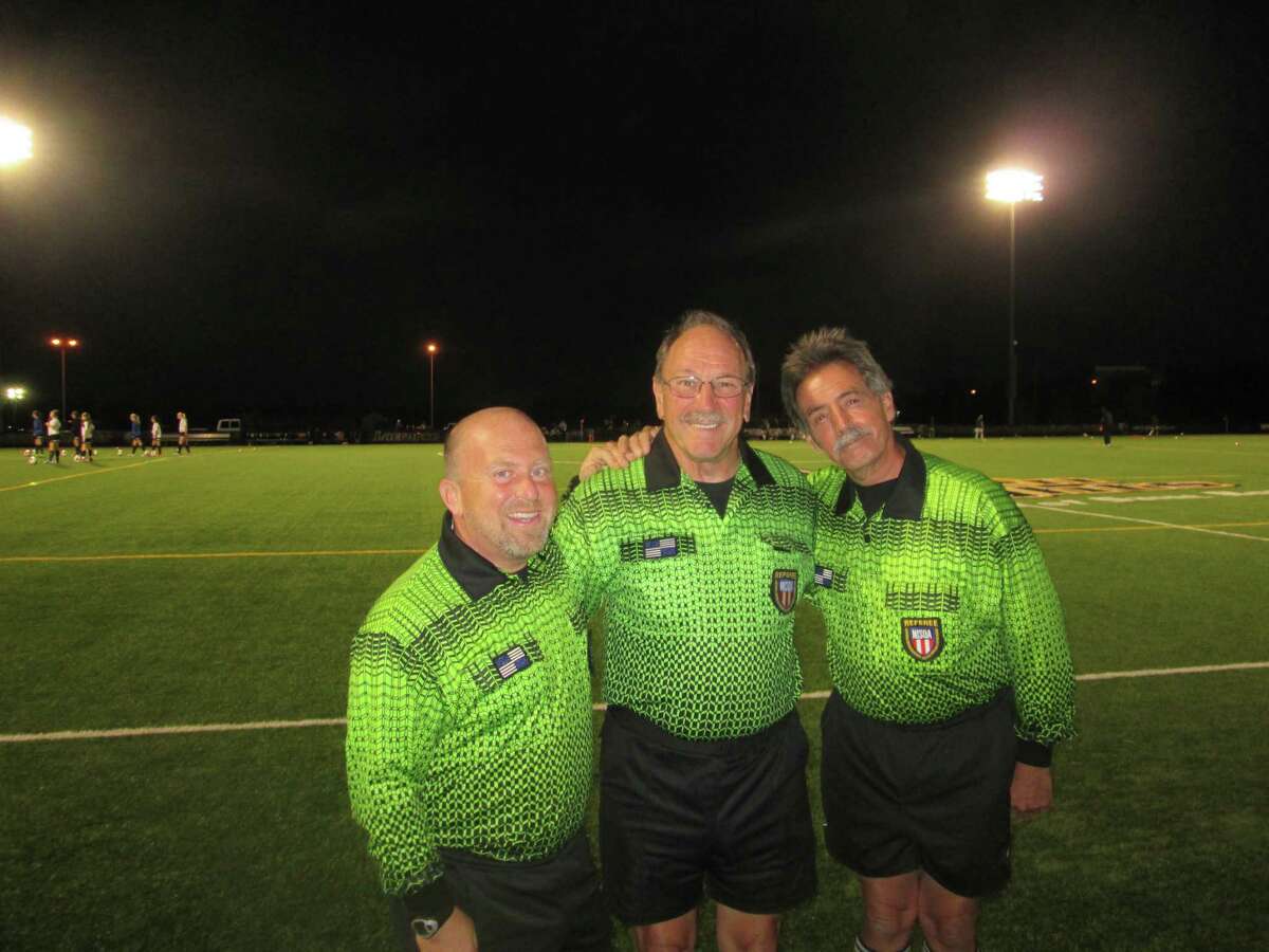 Referees, from left, Aaron Corman, Neil Riddell and Ronald Clark pose before a soccer match. (Provided)