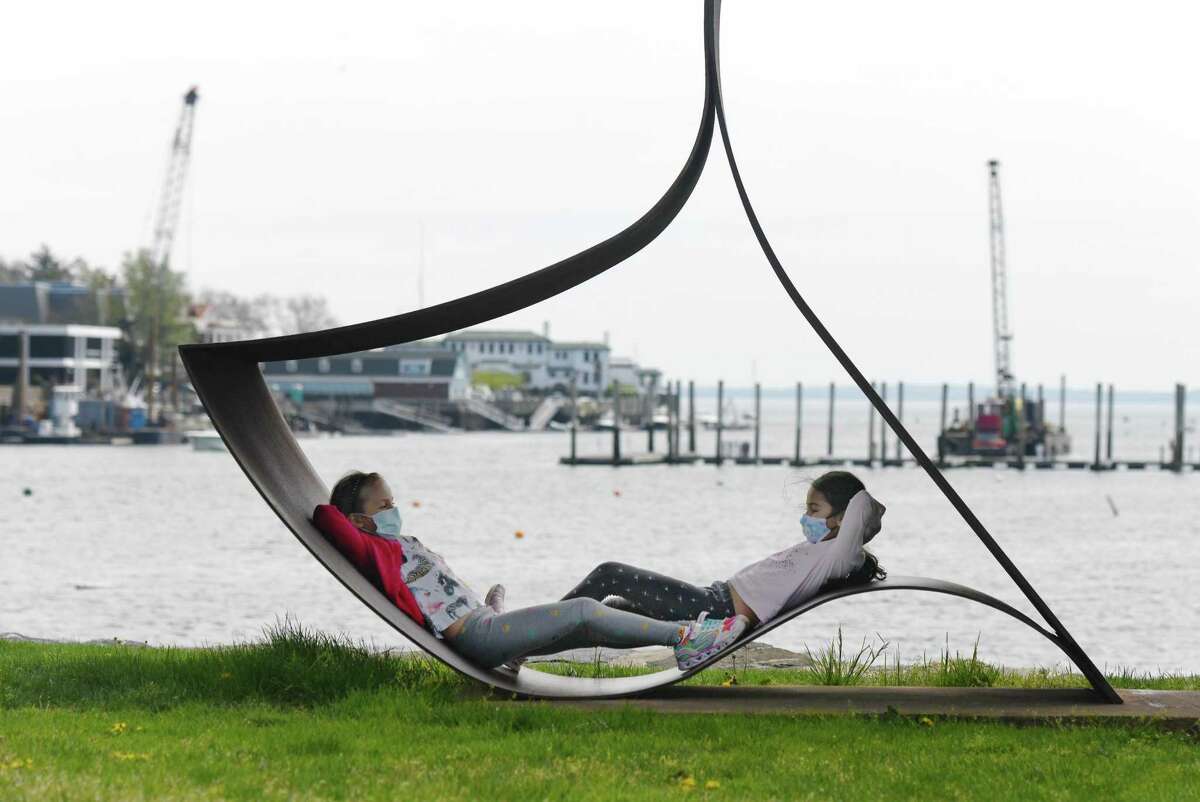 Alisa, left, of New York, and Lola, of Stamford, both 8, lounge on Lisa Katzen's 1976 sculpture "Priapos" at Roger Sherman Baldwin Park on a sunny day in Greenwich, Conn. Sunday, May 3, 2020.