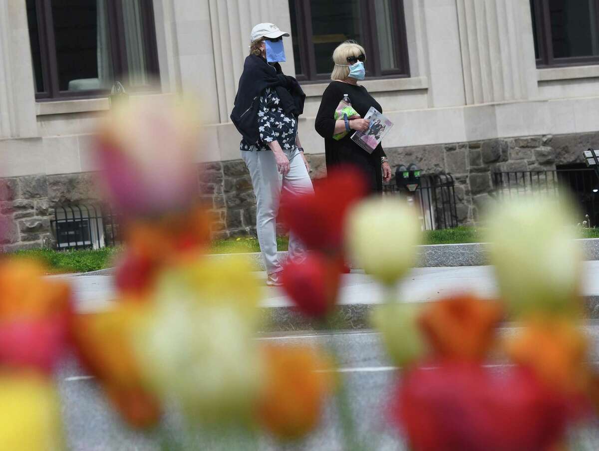 Two women wear masks while walking down Greenwich Avenue on a sunny day in Greenwich, Conn. Sunday, May 3, 2020. With a high temperature in the upper-70s, the town saw lots of exhausted quarantiners active on the streets and in the parks.