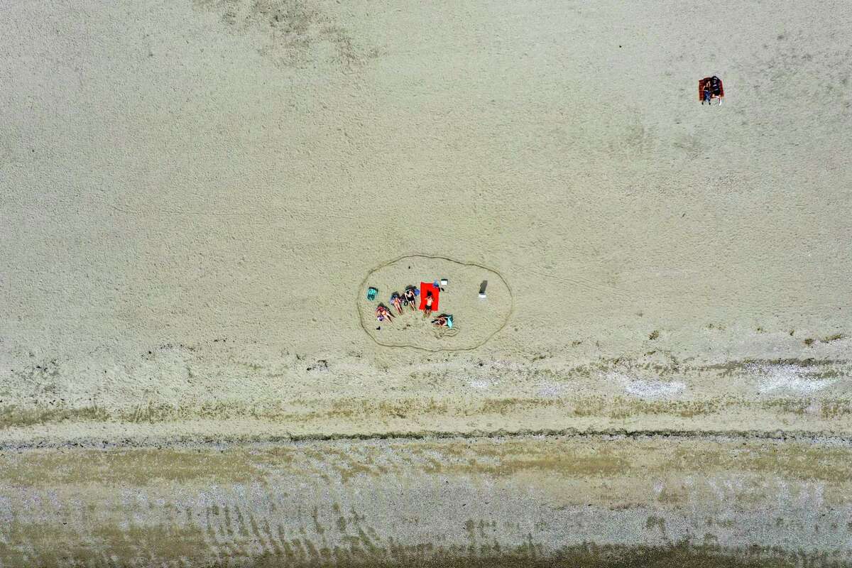 A group of people practiced social distancing by marking their area in the sand at Cove Island Beach in Stamford on Sunday.