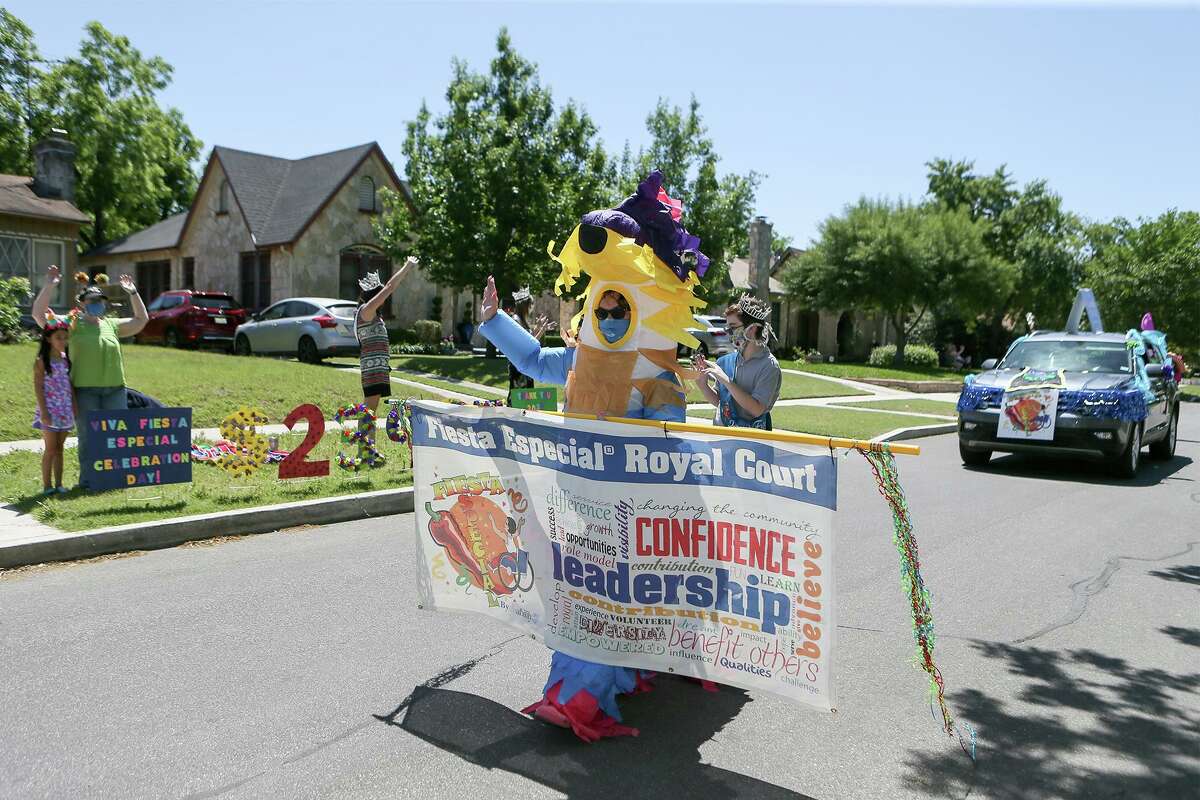 Anna Wimberley, dressed as Yata the Piñata, mascot of Fiesta Especial, waves to spectators standing and sitting the required social distance apart on Sunday, April 26, 2020, as she leads the parade, the grande finale of the Fiesta Especial Royal Court’s presentation of checks to local nonprofits. Fiesta Especial, organized by disABILITYsa, has been postponed to November, along with all other Fiesta events because of coronavirus restrictions, but the youth wanted to distribute their checks now when many nonprofits are struggling because of how hard the virus has hit the economy.