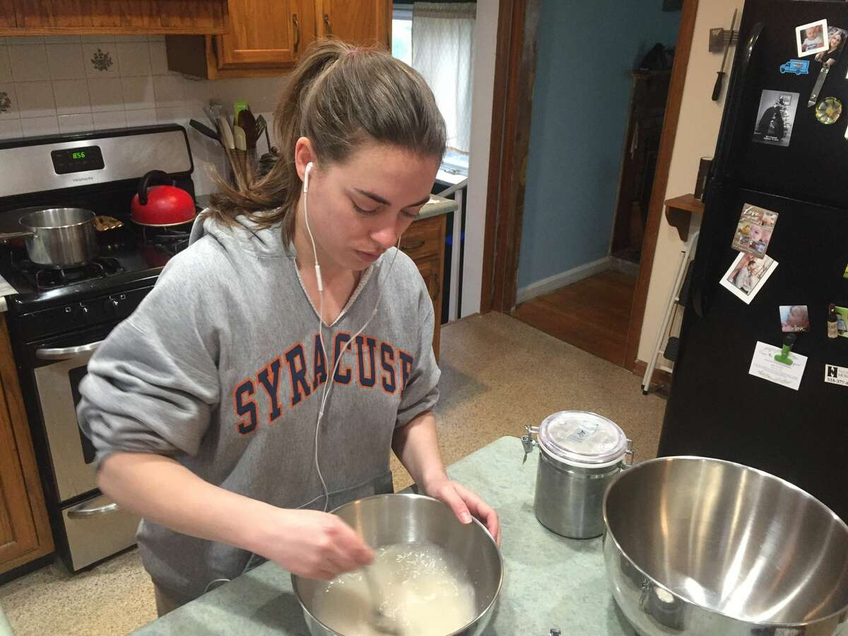 Features editor Sara Tracey stirring sugar into yeast and warm water to make a bread dough, a cooking project she started right before 9 a.m. on a recent Thursday.