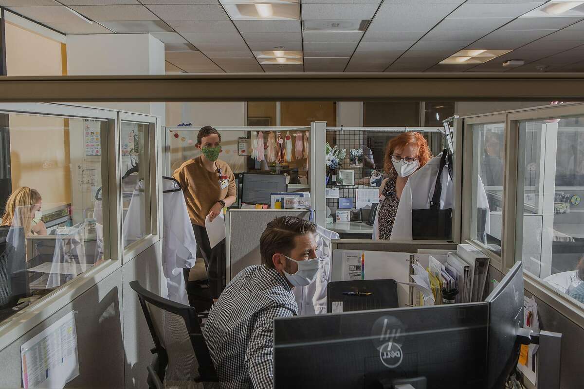 Workers at the office of Infection Prevention at University of California Irvine where protective barriers separate cubicles, Orange, Calif., April 27, 2020. As businesses contemplate the return of workers to their desks, many are considering large and small changes to the modern workplace culture and trappings. (Alex Welsh/The New York Times)