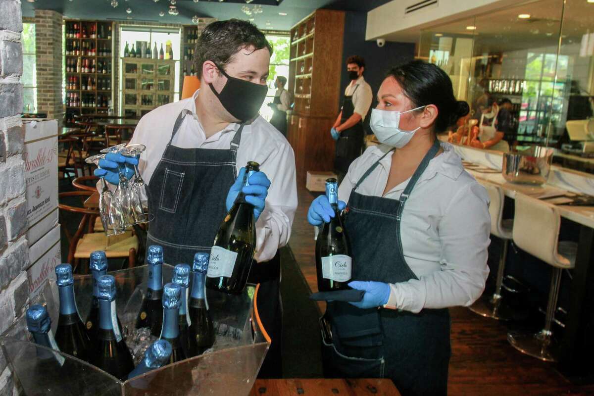 Waiters at a’Bouzy in Houston during their reopening on May 1, 2020. Business shutdowns to slow the spread of the coronavirus led to record numbers of unemployment claims, more than 2 million in Texas.