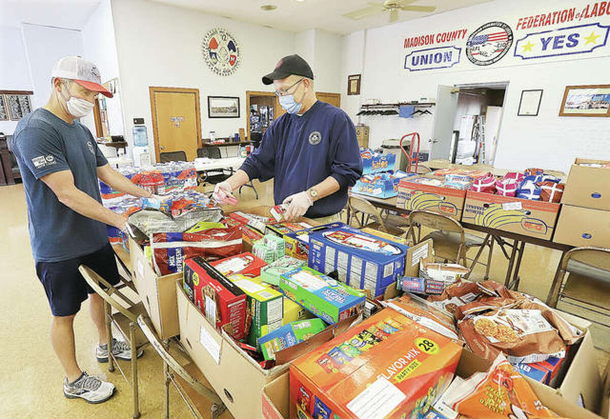 Terry Biggs, left, AFL-CIO United Way liaison, and Dean Webb, right, president of the federation, look over tables full of snacks purchased by the AFL-CIO to be delivered to nurses and doctors working at area hospitals.