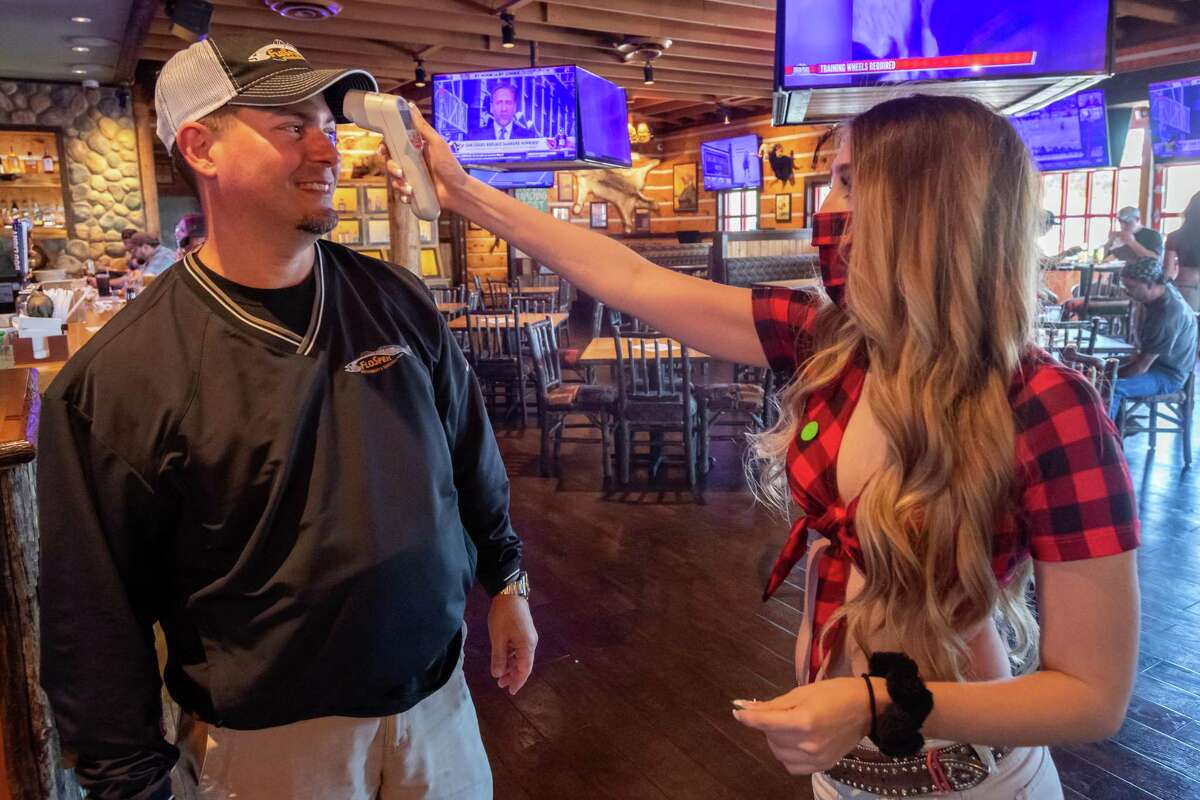 Katelyn Schall takes the temperature of patron Vince Rinando as he comes into Twin Peaks on the first day of business reopening. Photo made on May 1, 2020.
