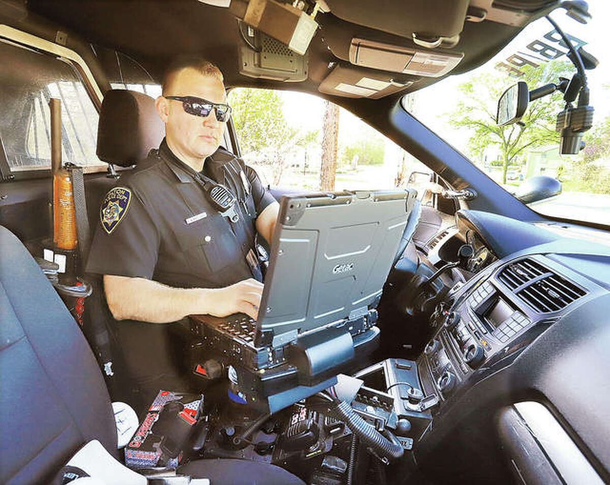 Alton Police Officer John Wimmersberg works at the data terminal inside his patrol car while on duty in Alton.