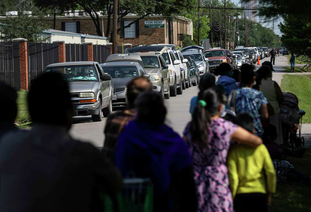 Hundreds of people gather for food being distributed by the Houston Food Bank and volunteers with San Mateo Episcopal Church on Saturday, April 25, 2020, at the church in Houston.
