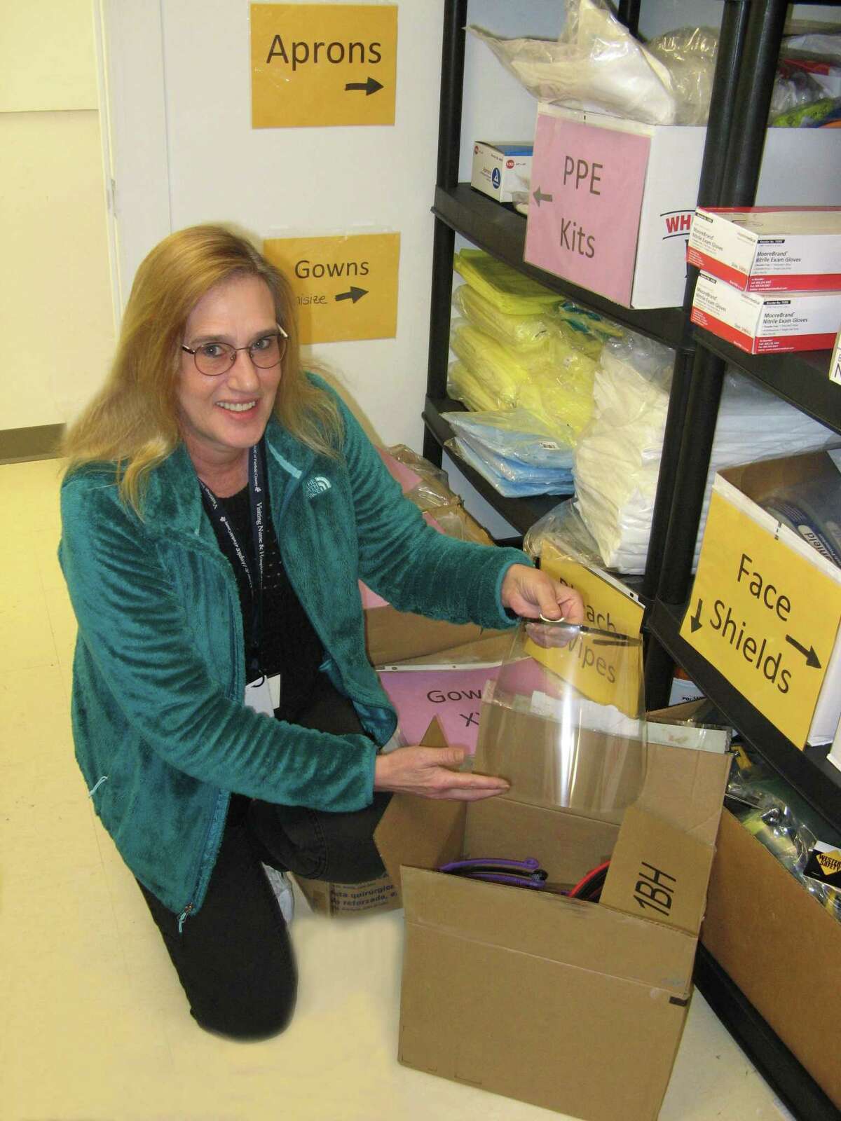 Ellen Dobson opens a box of face shields donated to Visiting Nurse & Hospice of Fairfield County by the Wilton Health Department.