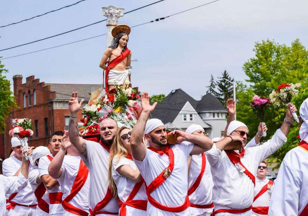 The statue of St. Sebastian is hoisted and carried around the block by the I Nuri, Middletown church parishioners who run barefoot to 155 Washington St. to converge on the church.