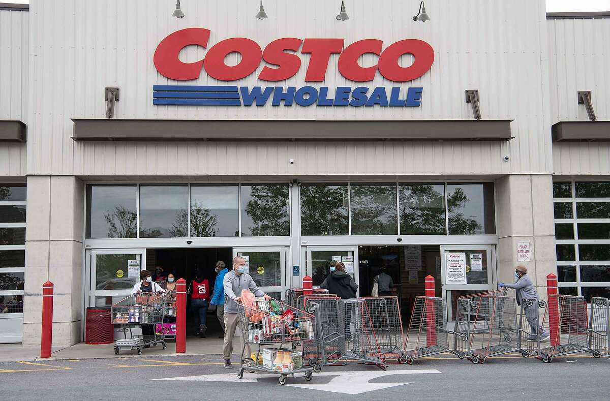 Shoppers walk out with full carts from a Costco store on May 5, 2020.
