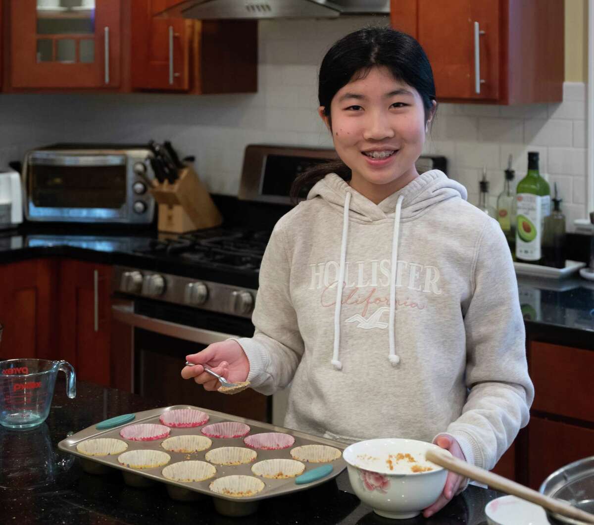 Annabelle Zheng, a seventh grader at Middlebrook School, bakes mini raspberry cheesecakes at home in Wilton, Ct. May 2020
