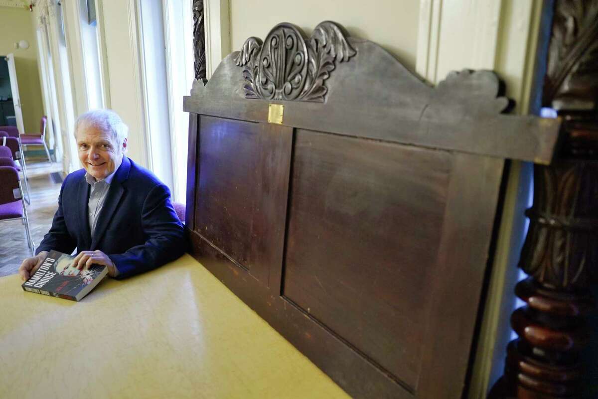 Jack Casey, the author of Hamilton's Choice, poses next to Aaron Burr's bed headboard and posts at The Hart Cluett Museum on Tuesday, May 5, 2020, in Troy, N.Y. Hamilton was killed in a duel with Aaron Burr. (Paul Buckowski/Times Union)