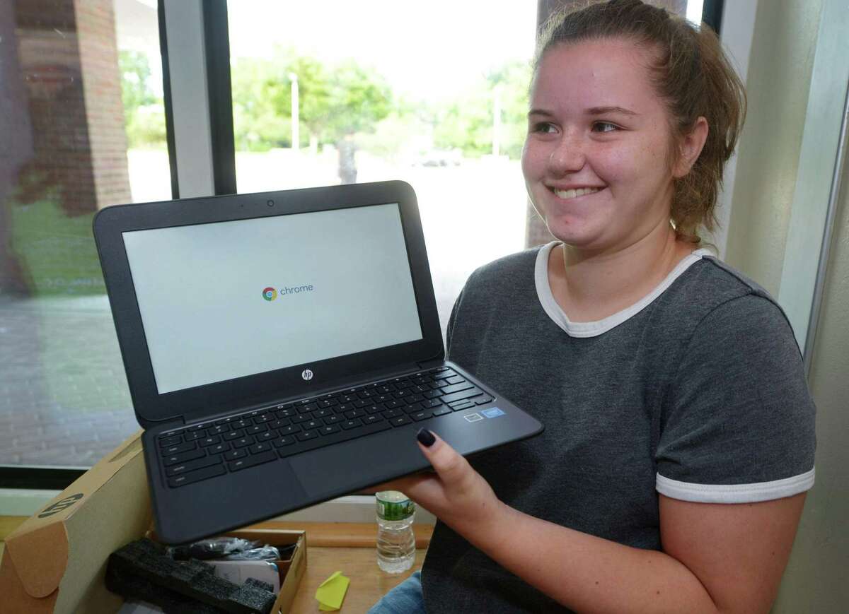 Incoming Brien McMahon High School freshman Sophie Chironna receives her Chromebook Aug. 16, 2018 as part of the Norwalk Public Schools 1:1 Digital Learning Initiative at the school in Norwalk, Conn. Soon all Norwalk students across every grade will have their own device to participate in distance learning.