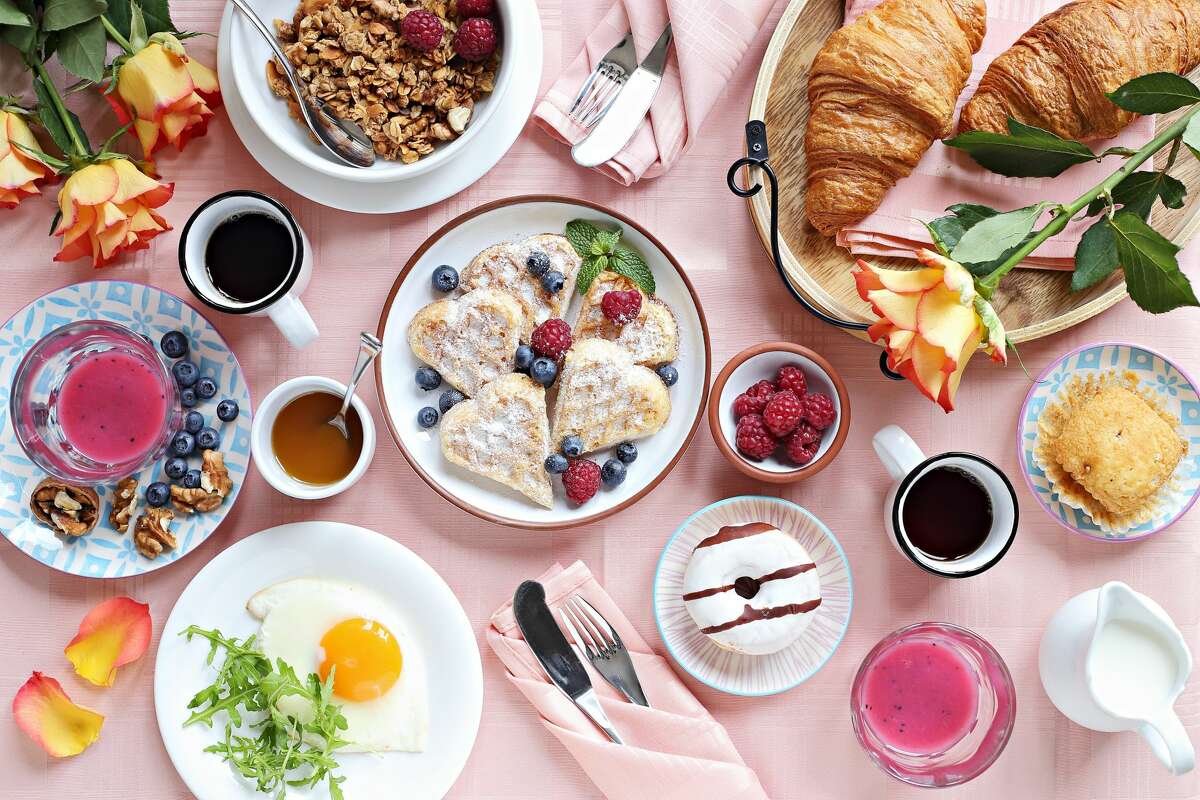 Festive brunch or breakfast set for Valentines day, Mothers day or Easter. Pink background. Overhead view .