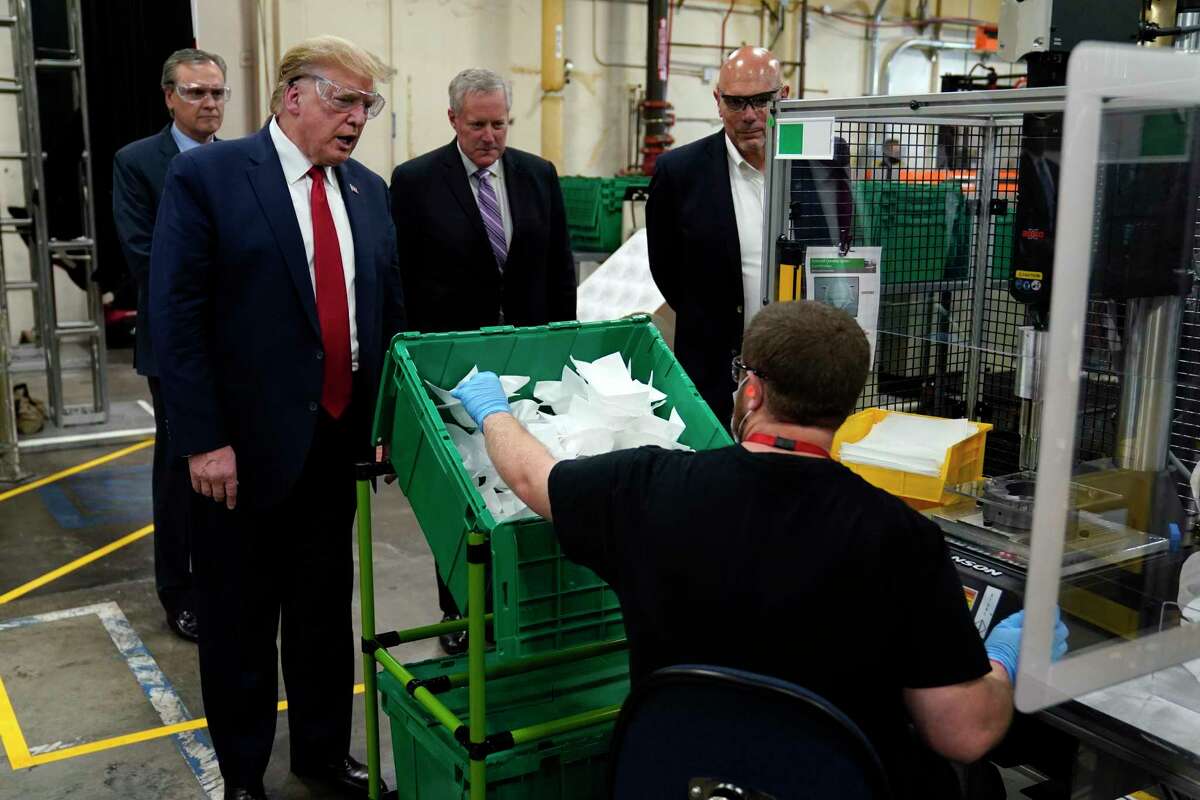 President Donald Trump participates in a tour of a Honeywell International plant that manufactures personal protective equipment, Tuesday, May 5, 2020, in Phoenix, with Tony Stallings, vice president of Integrated Supply Chain at Honeywell, right and White House chief of staff Mark Meadows.