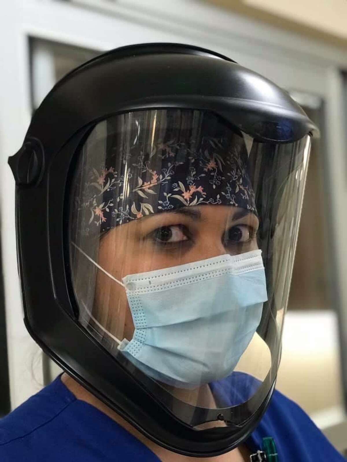 The Facebook group, Create Face Mask Covers Houston, has created more than 12,400 masks, caps and face shields for those on the front lines of COVID-19. Here, a health care worker wears a surgeon cap that makes wearing a face shield more comfortable.
