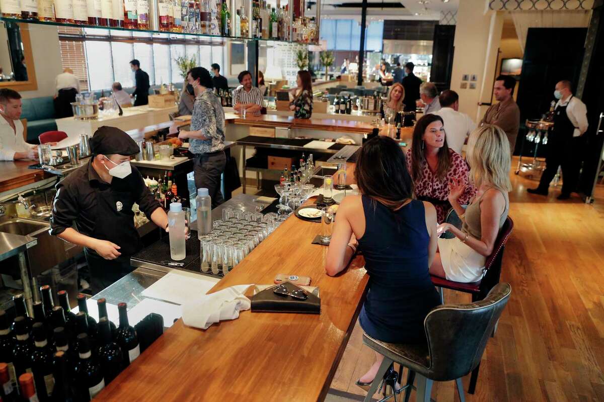 Customers at the bar area with the dining room in the background as around 7pm during the first night of reopening of the Doris Metropolitan restaurant Friday, May 1, 2020 in Houston, TX.
