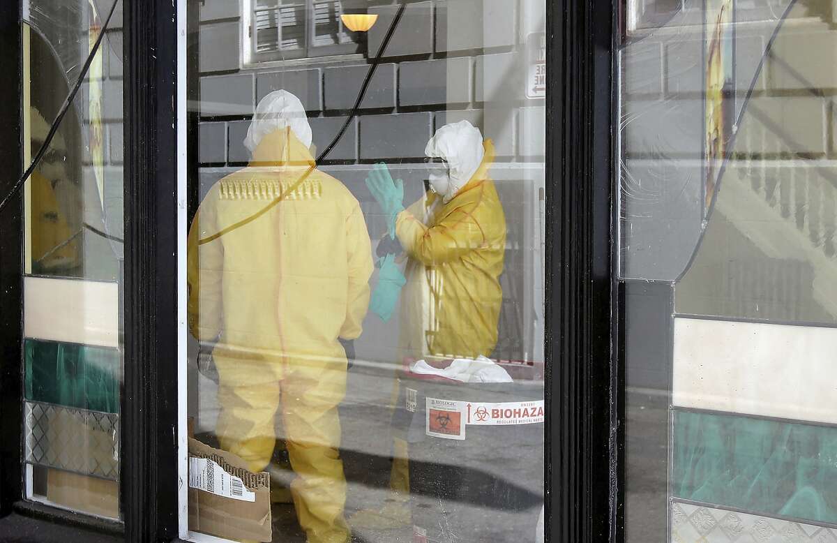 FILE - In this Thursday, April 2, 2020, file photo, workers in hazardous material suits clean inside the Abigail Hotel in San Francisco. The hotel is one of several private hotels San Francisco has contracted with to take vulnerable people who show symptoms or are awaiting test results for the coronavirus. Gov. Gavin Newsom, who made solving the state's homelessness crisis a priority even before the pandemic struck, announced in mid-March his administration was negotiating with 900 hotels to house the homeless. Two weeks ago he announced Project Roomkey, a program in which the Federal Emergency Management Agency will pay 75% of costs associated with housing some homeless, including people who test positive or may have been exposed to the virus, and older homeless people and those with underlying health conditions. (AP Photo/Jeff Chiu, File)