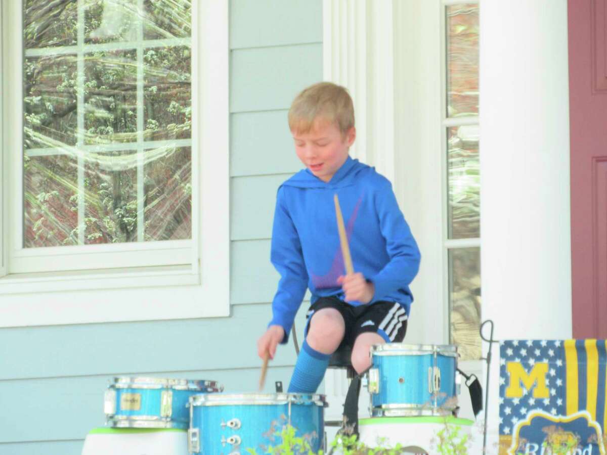 Quintin Rivard, 7, of Midland, plays the drums on his family's front porch on Monday, May 4. (Victoria Ritter/vritter@mdn.net)