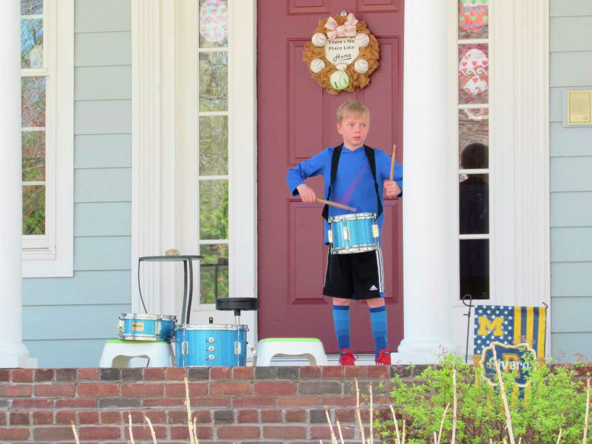 Quintin Rivard, 7, of Midland, plays the drums on his family's front porch on Monday, May 4. (Victoria Ritter/vritter@mdn.net)