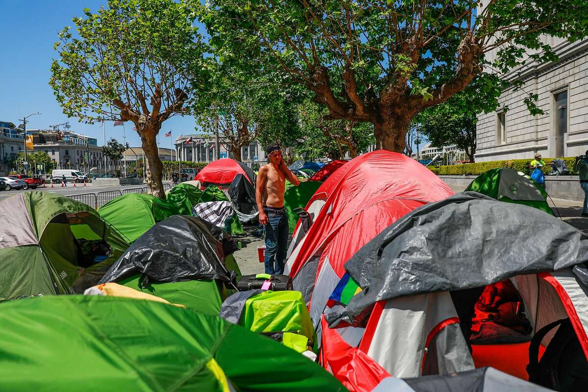 Homeless man Jacob Corbin, 30, stands in an encampment on Fulton Street on Wednesday, May 6, 2020 in San Francisco, California.