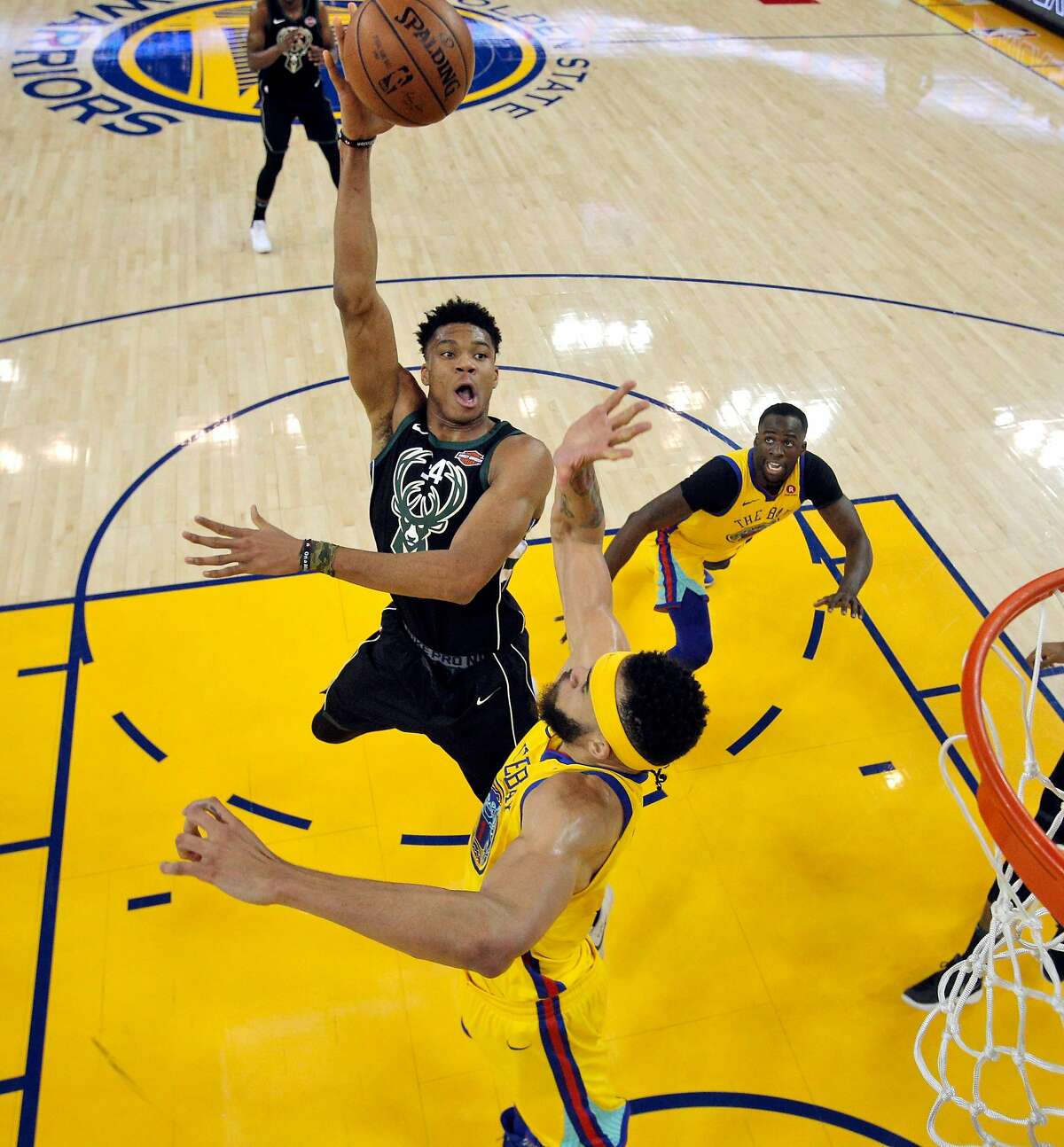 Giannis Antetokounmpo (34) puts up a shot over JaVale McGee (1) in the first half as the Golden State Warriors played the Milwaukee Bucks at Oracle Arena in Oakland, Calif., on Thursday, March 29, 2018.