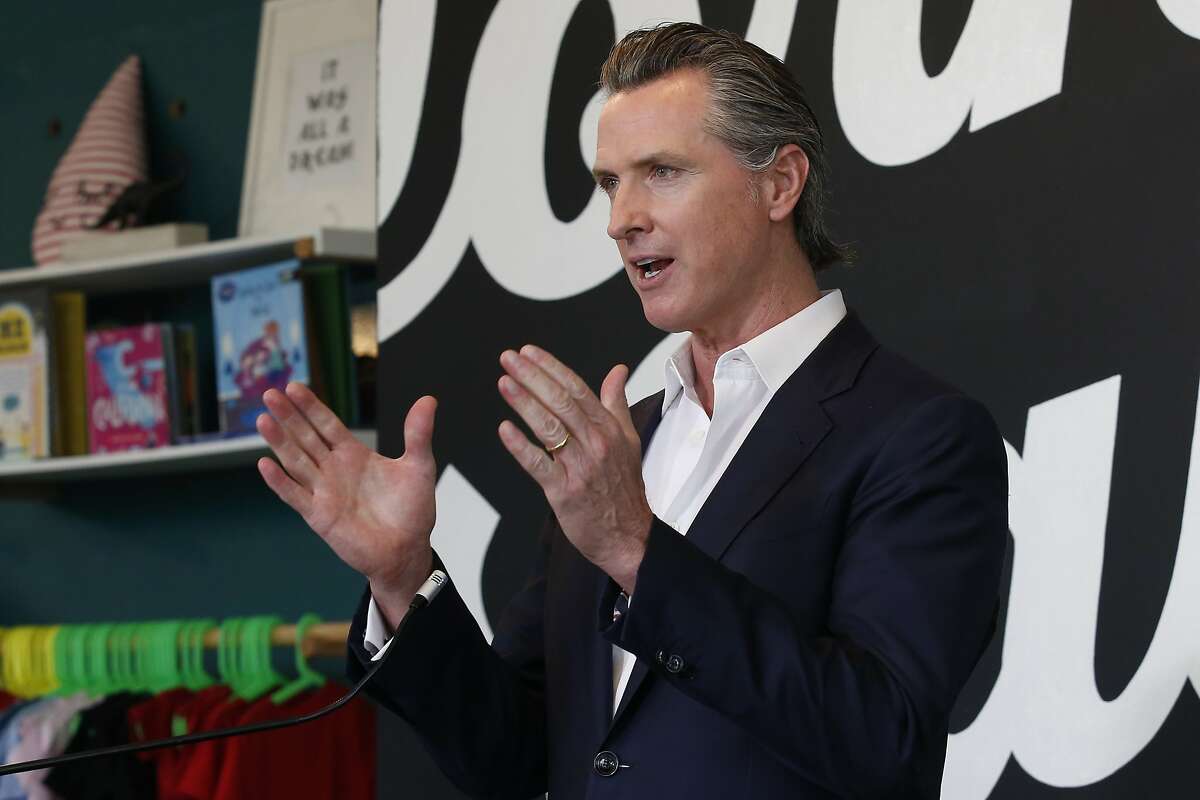 FILE - In this Tuesday, May 5,2020. file photo Gov. Gavin Newsom discusses his plan for the gradual reopening of California businesses during a news conference at the Display California store in Sacramento, Calif. Newsom on Wednesday, May 6, 2020, said he is issuing an executive order allowing employees across California's economy to apply for worker's compensation if they contract the coronavirus, with a presumption that it was work-related unless employers can prove otherwise.