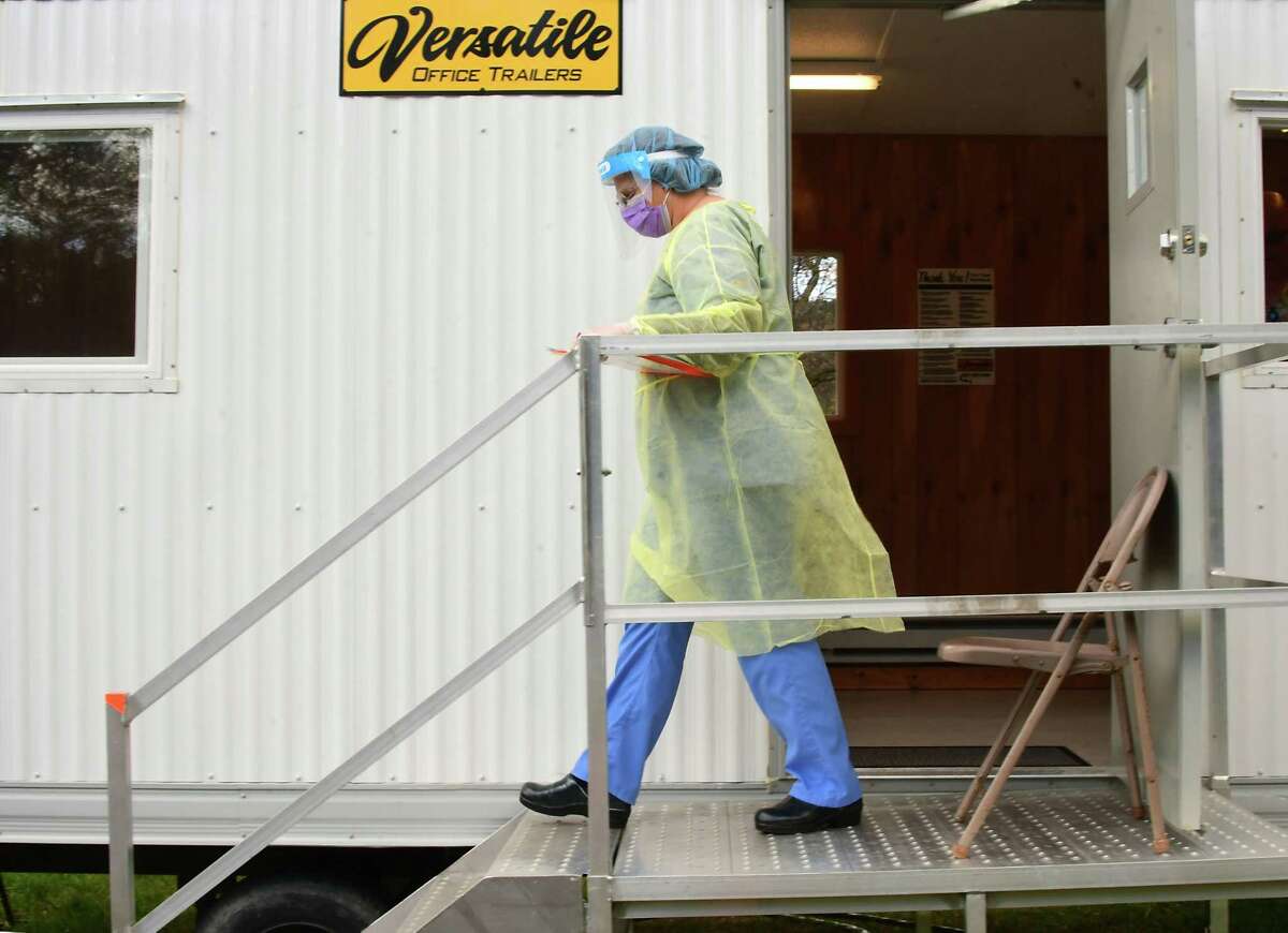 A healthcare worker leaves a trailer to greet a patient at a COVID-19 testing site behind Warren County Municipal Center on Thursday, May 7, 2020 in Queensbury, N.Y. (Lori Van Buren/Times Union)