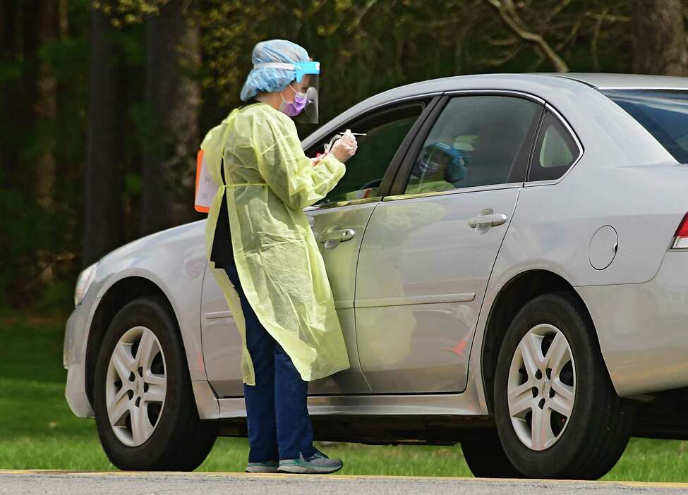 A healthcare worker gets a sample from a patient at a COVID-19 testing site behind Warren County Municipal Center on Thursday, May 7, 2020 in Queensbury, N.Y. (Lori Van Buren/Times Union)