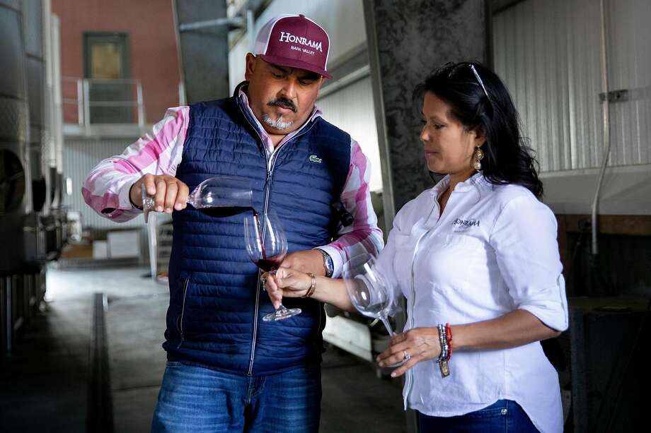 Juan Puentes pours a taste of Pinot Noir straight from the tank for his wife Miriam at the Honrama Cellars tasting room. Photo: Jessica Christian / The Chronicle