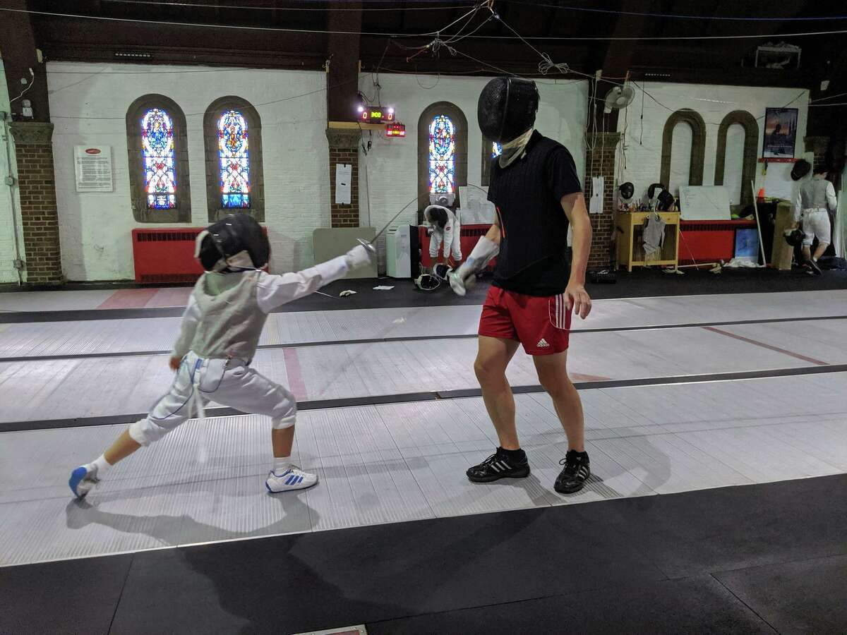A student practicing fencing with Jim Roberts at the Fairfield Fencing Academy.
