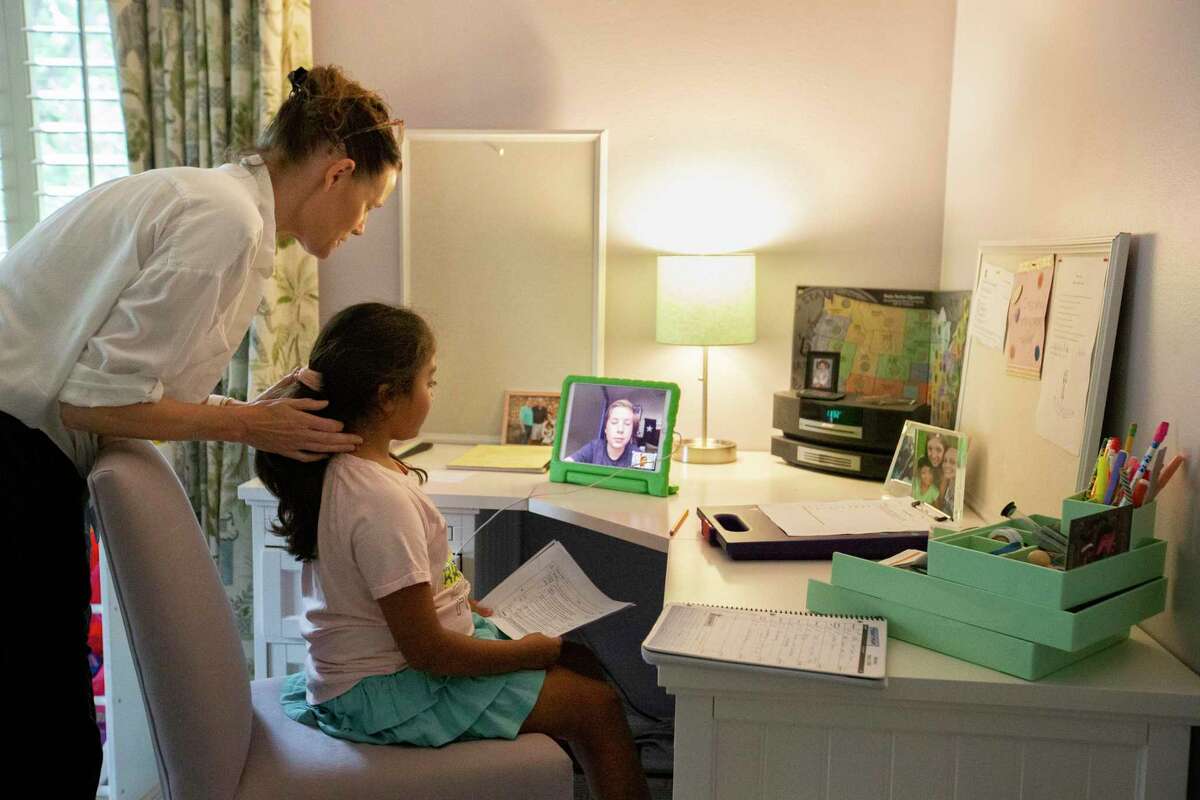 Quenby Mott helps her daughter, Sydney Mott, 9, sets up a 30-minute Zoom meeting with Kinkaid School 10th-grader Clayton Rice Tuesday, May 5, 2020, in Houston.