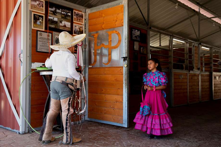 Andres Puentes, 11, (left) and Paula Puentes, 7, get dressed in traditional charro clothing before riding their horses at Honrama Ranch in Napa, Calif. Tuesday, May 5, 2020. Juan and Miriam Puentes own Honrama Cellars, and before the crisis they sold 100% of their wine through their tasting room. With their tasting room closed, they're worried about the future. Photo: Jessica Christian / The Chronicle