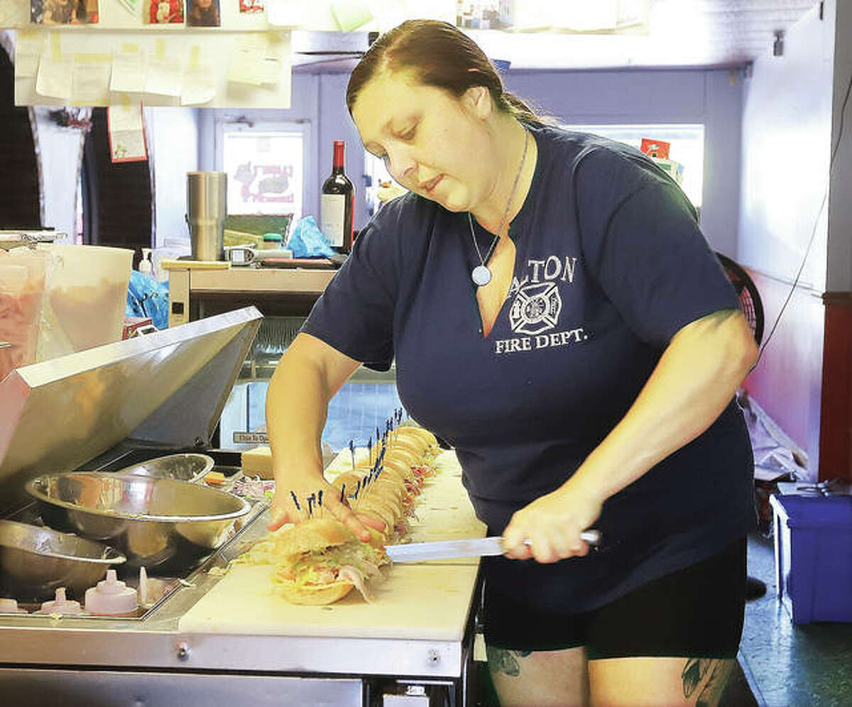 Danielle Singleton, manager of Sammi’s Sandwiches at Norb’s, cuts up a fresh sandwich Thursday. Owners Scott and Lisa Yarbrough have launched a campaign to raise $10,000 for the Boys & Girls Club of Alton.