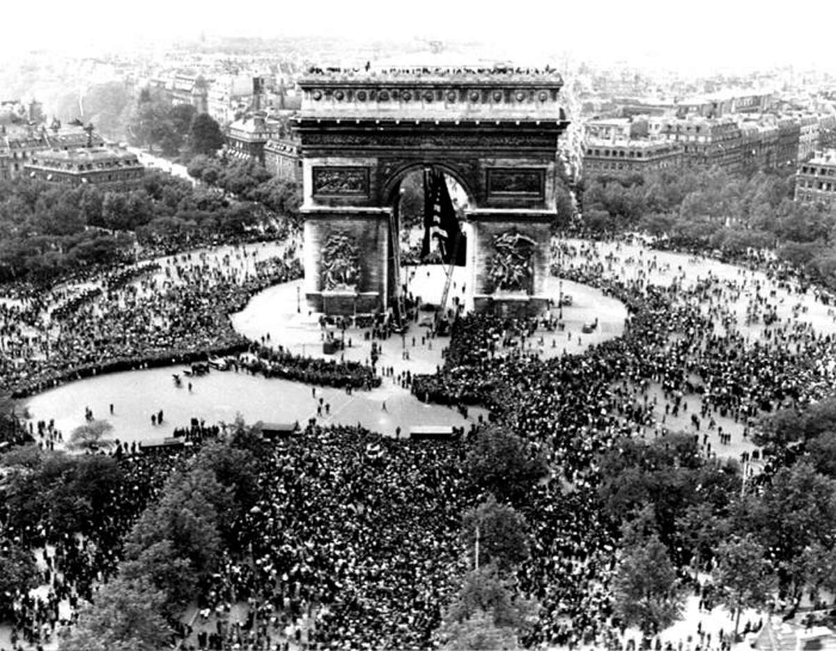 This is an aerial view of the Arc de Triomphe in Paris on VE Day, May 7, 1945, shows thousands of French people celebrating the announcement of Germany's unconditional surrender to the Allies. British, American and French servicemen mingled with the crowds who sang and danced throughout the night.