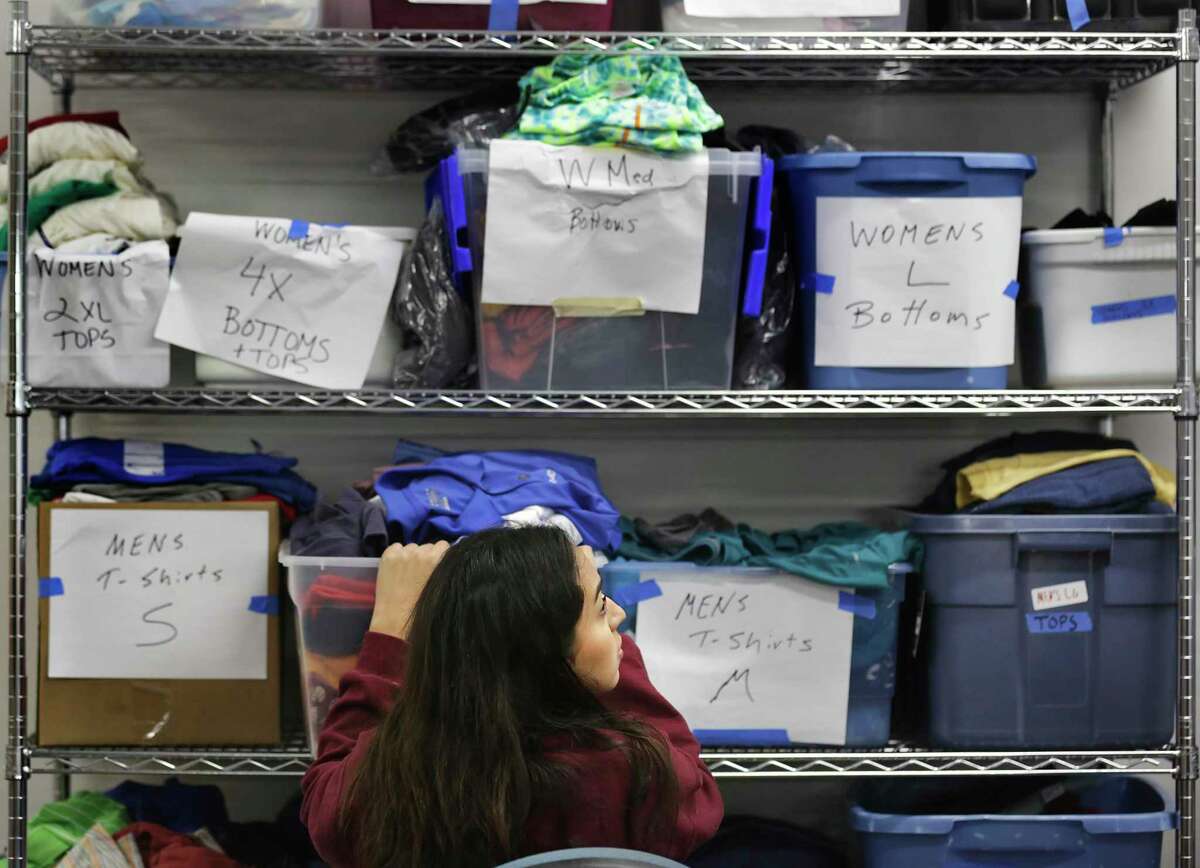 Aubrie Grimaldo, an intern at the Christian Assistance Ministry, sorts through clothing to be handed out the homeless.