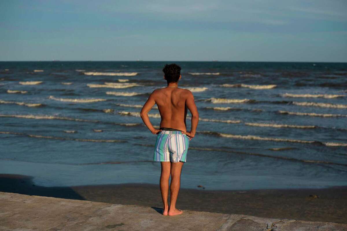 A beachgoer looks out over Galveston Beach on May 2, 2020 in Galveston, Texas, amid the coronavirus pandemic. - Texas beaches were ordered to be opened on May 1, 2020. In a statement, the City of Galveston said, "The City of Galveston's top priority is the health of our residents. We strongly urge our residents to continue taking health precautions and following the CDC, state and health district guidelines regarding COVID-19, including social distancing and avoiding gatherings of more than 10." The reopening is a first step in Galveston's goal to rebound from the pandemic and "salvage the summer," as coined during the tourist town's. (Photo by Mark Felix / AFP) (Photo by MARK FELIX/AFP /AFP via Getty Images)