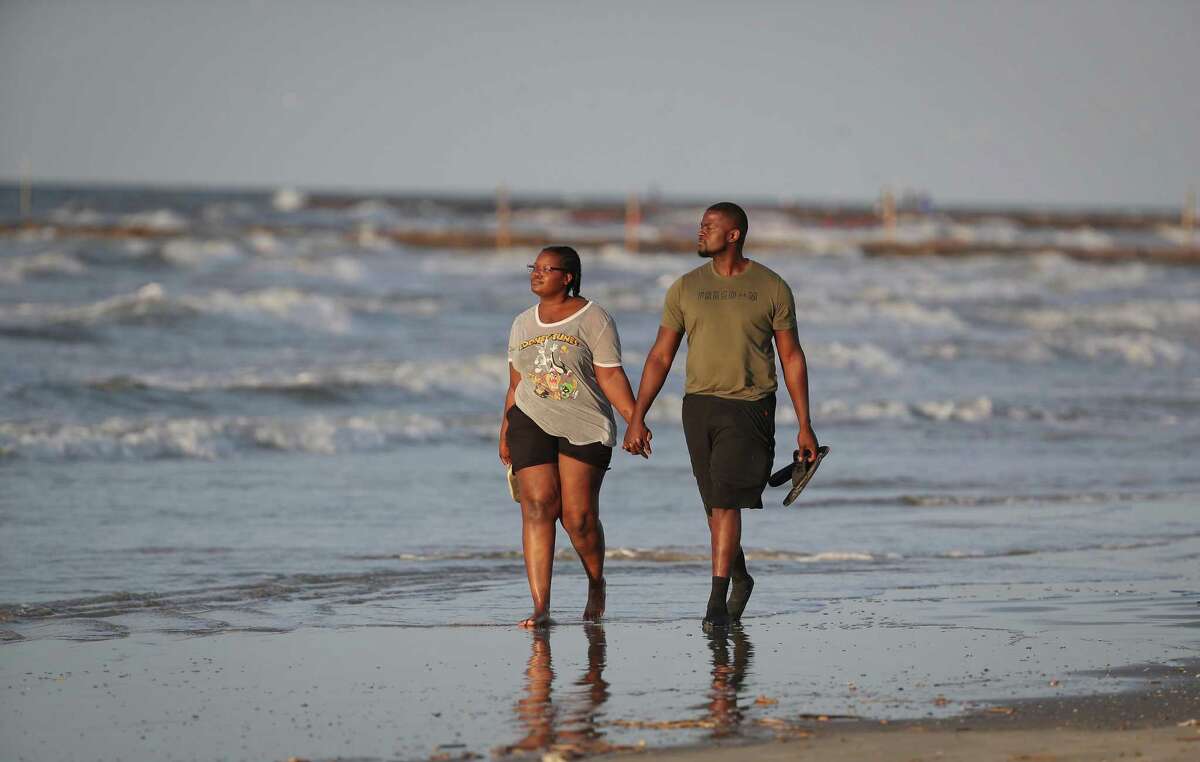 Tulsa, OK residents Sierra Higbee and Philanteus Jarrett walk the beach after the city of Galveston partially reopen public beaches after closing them for nearly a month due to the novel coronavirus outbreak Monday, April 27, 2020, in Galveston. Higbee said that she just need a break from the quarantine and when she heard that Galveston's beaches were opening up, she and Jarrett booked a flight to Texas.