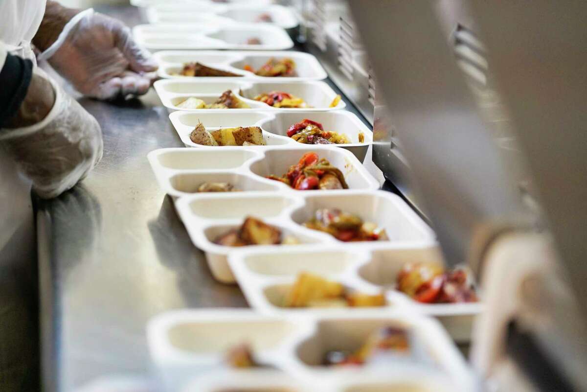Meal trays are filled with food at the Peter Young Housing, Industries, and Treatment organization on Thursday, May 7, 2020, in Menands, N.Y. Along with the 250 meals a day for the senior home meal food delivery program, workers are also prepping meals that will be distributed on Friday at 45 South Ferry from 10am to 2pm or earlier if all the food is given out. The meals are open to anyone in need. (Paul Buckowski/Times Union)
