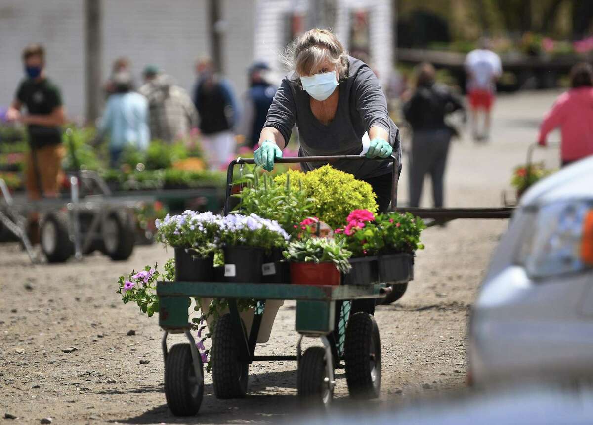 Customers wear masks as they shop for flowers and other plantings at Filanowski Farms on Wheelers Farm Road in Milford, Conn. on Thursday, May 7, 2020.