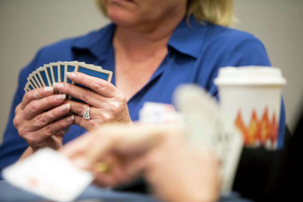 Lolly Prince holds her cards closely while Penny Foote plays a card during a bridge game. Steve Becker teaches a weekly two hour class at the Greenwich YWCA to a class of about 40 people on Friday, October 27, 2017. The class begins with tables of four playing hands preselected to isolate play from luck. After the class practices he charts out their gameplay giving him the chance to critique their choices.