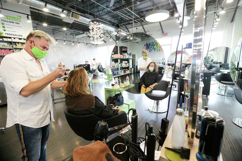 <p>Alden Clark, owner of Salon on Kirby works on Pat Gilmore-Maass' hair at the salon in Houston on Friday, May 8, 2020.</p>