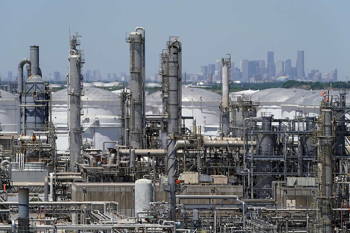 In this Thursday, April 30, 2020, photo a refinery along the Houston Ship Channel is seen with downtown Houston in the background.