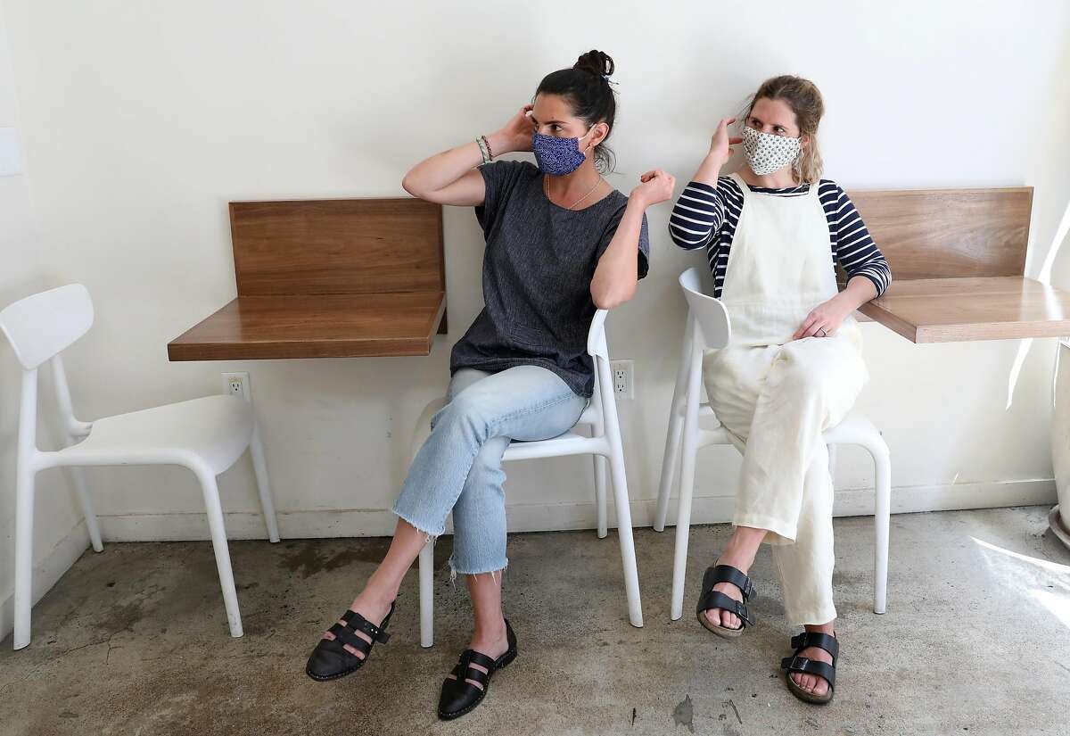 Nicole Fish (left) and Caitlin Meade (right) put on their masks at Native Co., a restaurant they opened in 2014 in the financial district seen on Thursday, May 7, 2020, in San Francisco, Calif. Native Co. was able to secure a $181,437 forgivable loan from the federal government as it stays open for delivery.