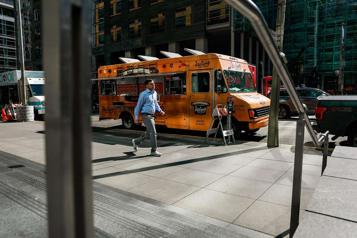 A man walks past the JapaCurry food truck during lunchtime in SOMA on Wednesday, March 11, 2020 in San Francisco, California. There are usually long lines for JapaCurry and other food trucks in the area. They said that the coronavirus which has forced employees to work from home has significantly impacted their sales.