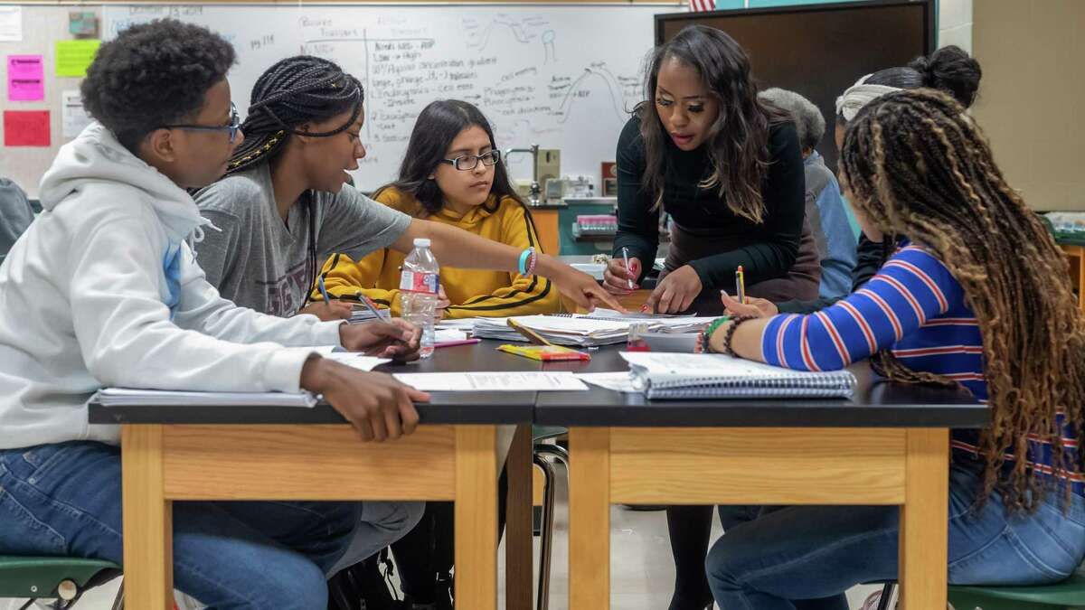 A teacher works with some of her ninth-grade students on a science project in 2019. Things won’t be back to normal until classrooms look like this again, and the pandemic demands support for public education as it evolves through this crisis.